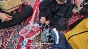 Children receiving shoes and clothing, a scene of humanitarian aid supported by crypto donations via Ethereum, embodying gratitude and relief for the Muslim Ummah.