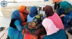 Women learning tailoring skills, a sewing workshop funded by a BTC donation, empowering them with income and dignity.