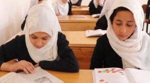 Young Muslim girls study in a classroom, supported by crypto Khums donations funding education for orphans.