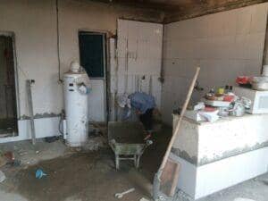 Construction or renovation in progress in a kitchen area with a person using a wheelbarrow and tools. Crypto zakat enables renovations like this, with donations via ETH supporting essential projects.