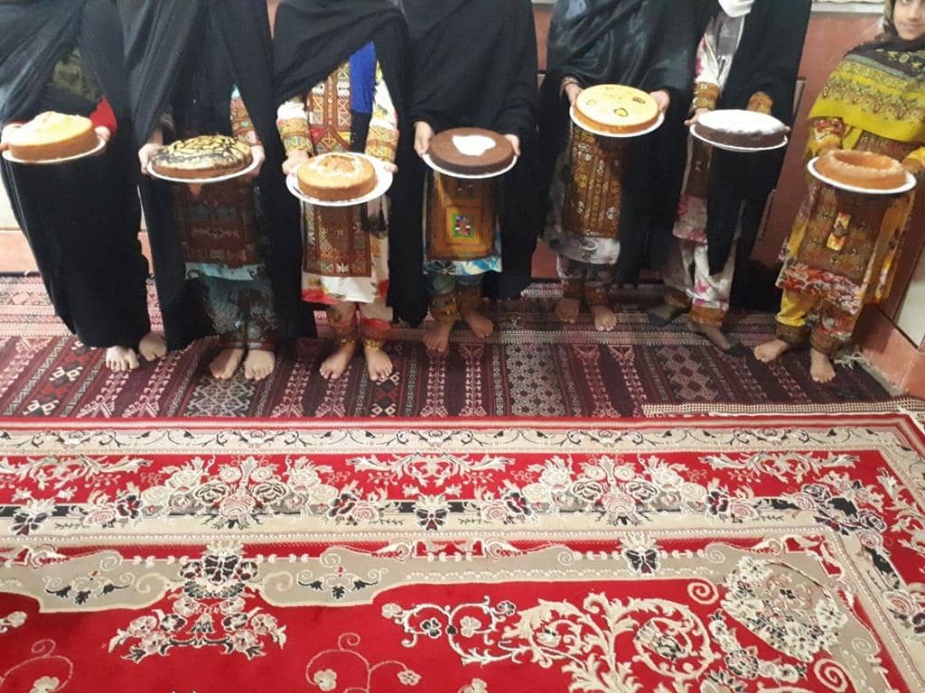 Children in traditional clothing holding cakes to celebrate Eid al-Fitr after their first fast, with crypto donations supporting Islamic relief.