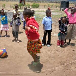 Children playing leapfrog outdoors with a ball, benefiting from crypto donations via USDT, supporting education for 49 orphans.