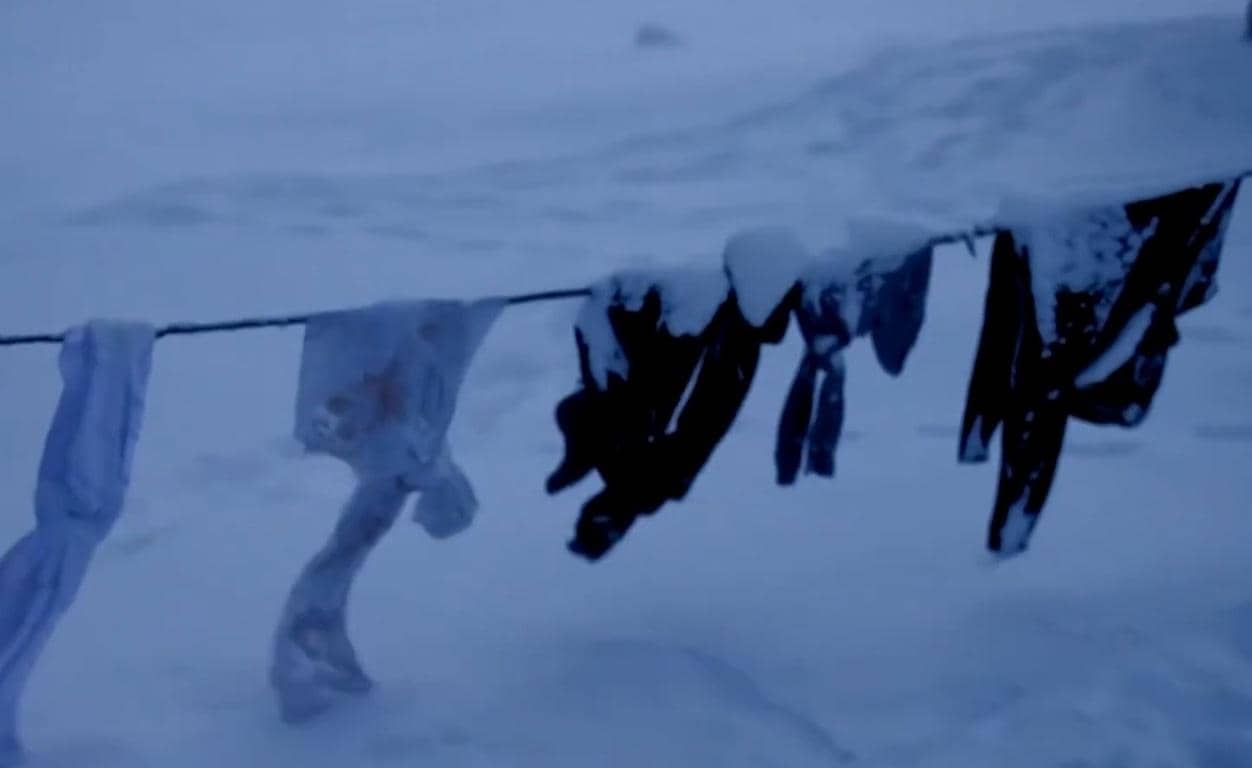 Winter relief for vulnerable families. Clothes on a clothesline in the snow, symbolizing hardship. Donate crypto like BTC or ETH for warmth.