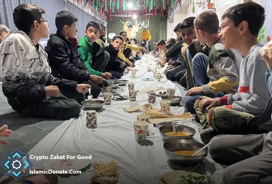 Boys gathered for a communal iftar meal, sharing food and cups. Supported by crypto donations, including ETH, to provide relief for the Muslim Ummah.
