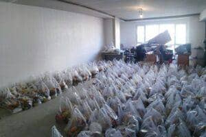 Rows of packed food bags prepared for distribution, featuring various food items, crypto donation support with ETH.