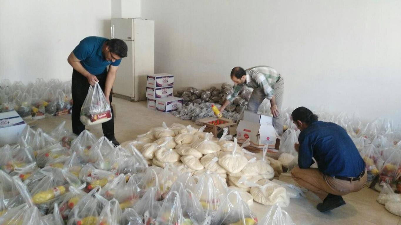 Volunteers packing grocery bags for donation, including staples like rice and oil, emphasizing crypto zakat and humanitarian aid.