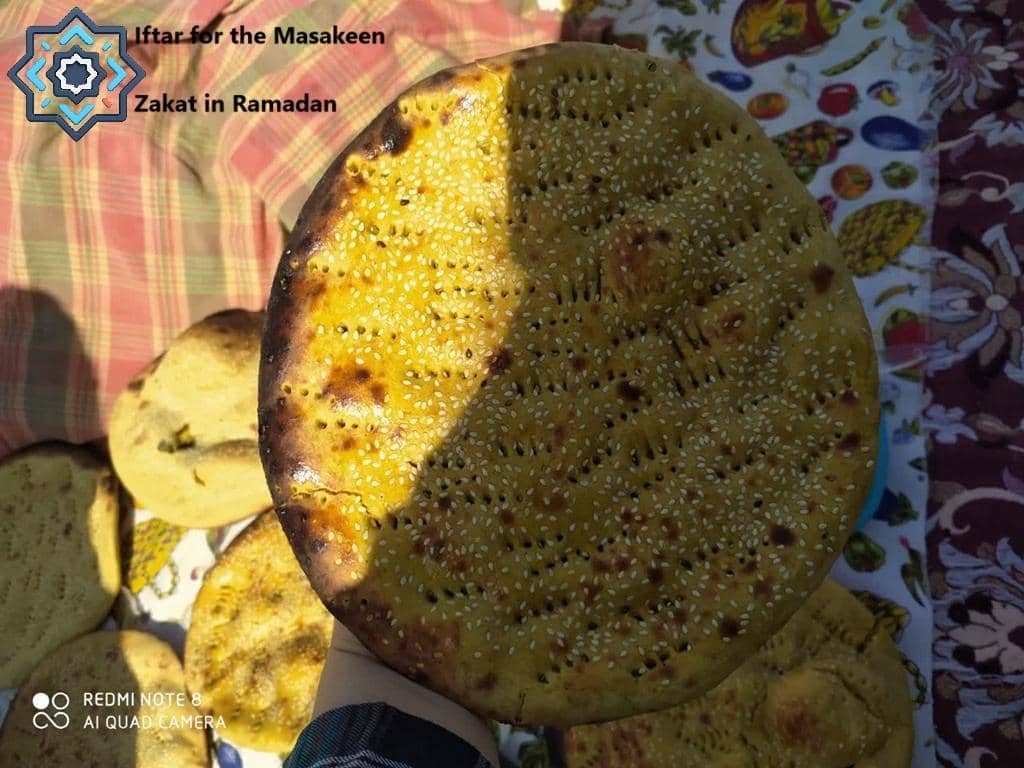 Freshly baked bread with sesame seeds, symbolizing Iftar for the Masakeen, made possible by crypto Zakat donations like BTC, providing nourishment to those in need.