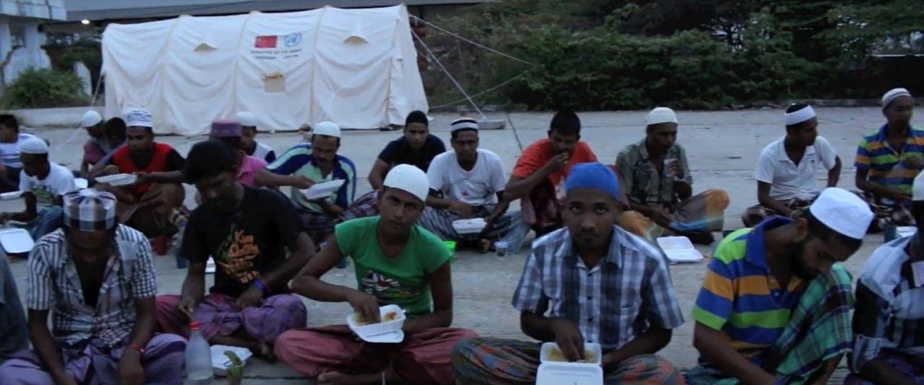 Muslims receiving Iftar meals from an Islamic charity, supported by crypto donations like BTC, during Ramadan.