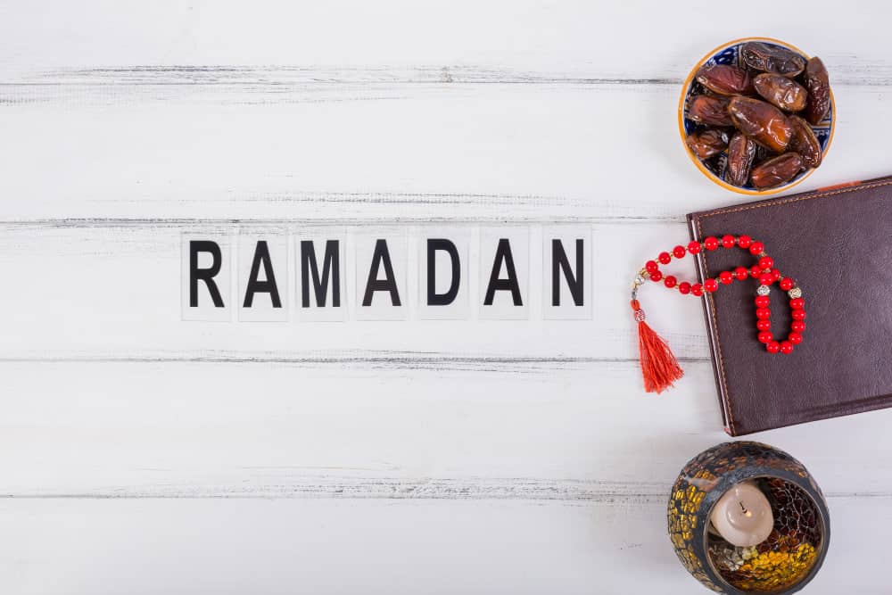 Ramadan decorations including dates, prayer beads, and a candle. Donate to Ramadan charity via crypto like USDT.
