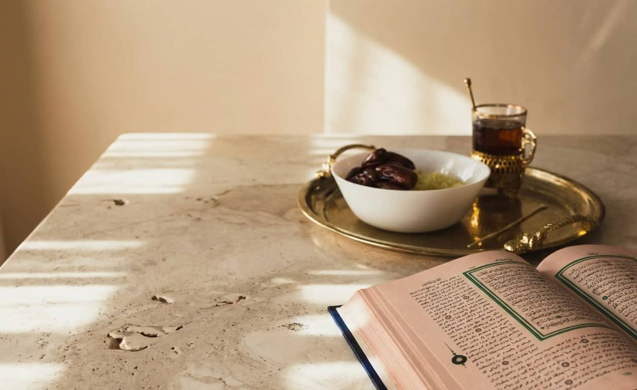 Ramadan preparation spread with dates, food, tea, and the Quran. Donate with USDT for Islamic charity.
