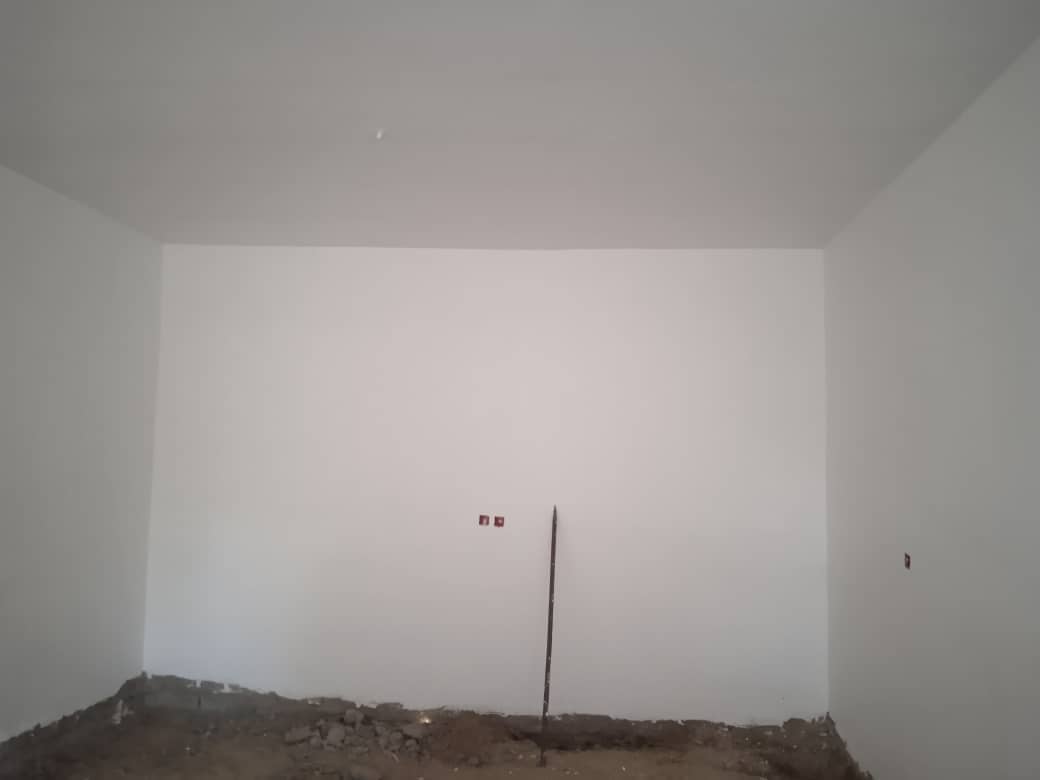 Unfinished room with white walls and piles of dirt and debris on the floor, illustrating the need for resources and rebuilding, with donations in BTC supporting social justice efforts.