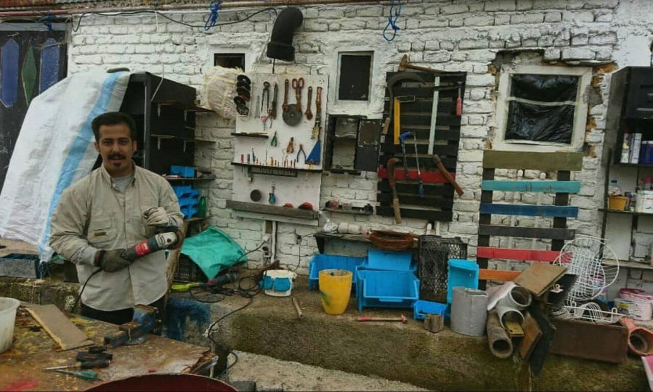 Man with grinder in workshop, Islamic charity empowers people with skills and tools for sustainable income, donations support training for a better future, processed via SOL.