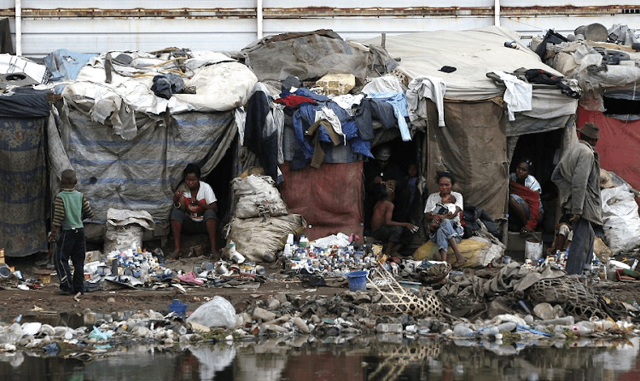 A group of people live in makeshift shelters amidst piles of trash and polluted water. Aid from crypto donations provides essential resources to impoverished families, with the current processing timestamp indicating support via ETH.