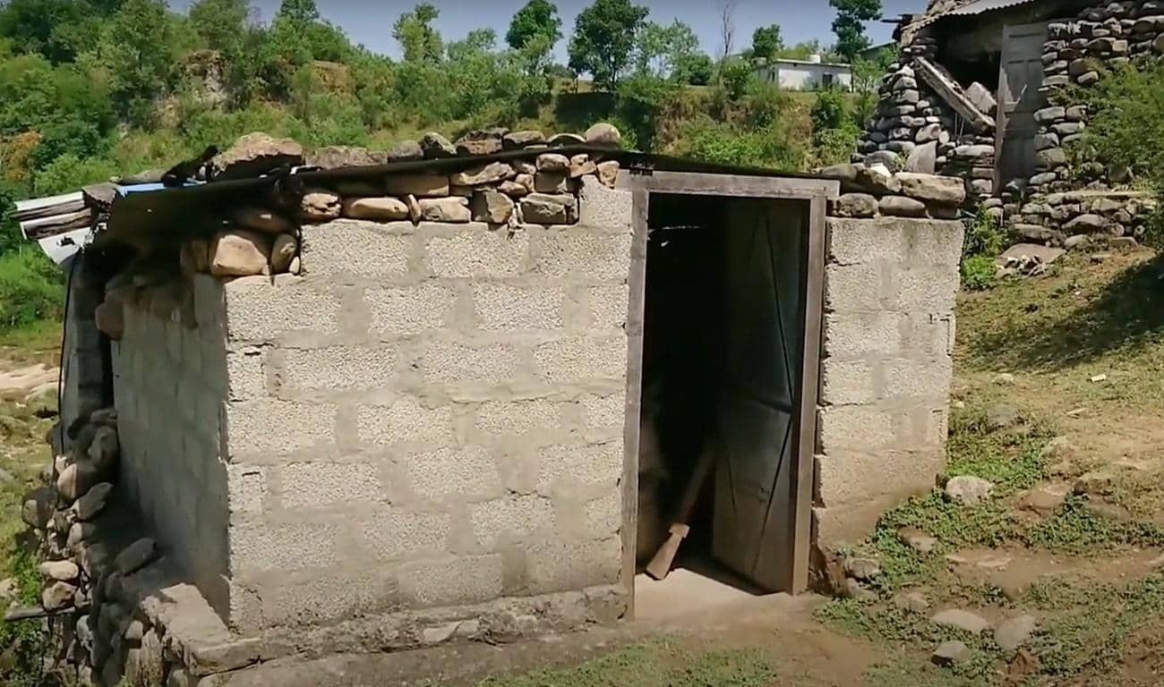 Stone and concrete structure with an open wooden door, used for aid distribution, symbolizing the impact of crypto Sadaqah donations via USDT.