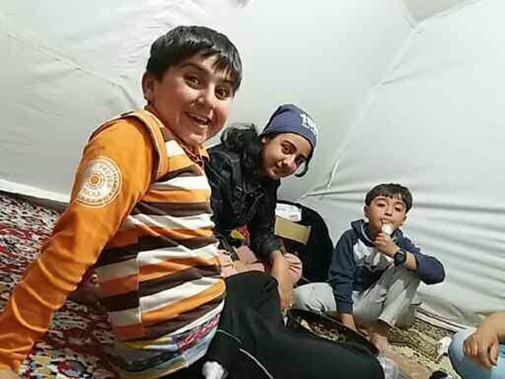 Children smiling inside a tent, holding food. This image highlights Islamic relief efforts, emphasizing support for struggling families and orphans through cryptocurrency donations, like PYUSD, to provide hot meals and aid.