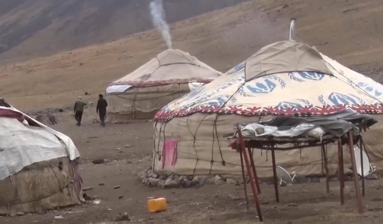 Yurts in a mountainous region, with smoke emanating from one, suggesting community support and education initiatives, possibly enabled by crypto donations like XRP.