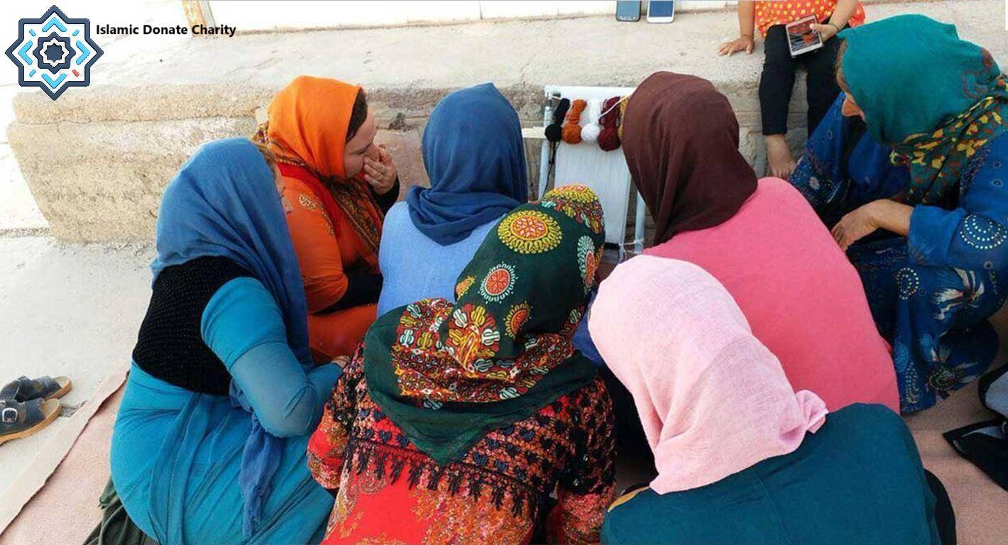 Women learning tailoring skills, a sewing workshop funded by a BTC donation, empowering them with income and dignity.