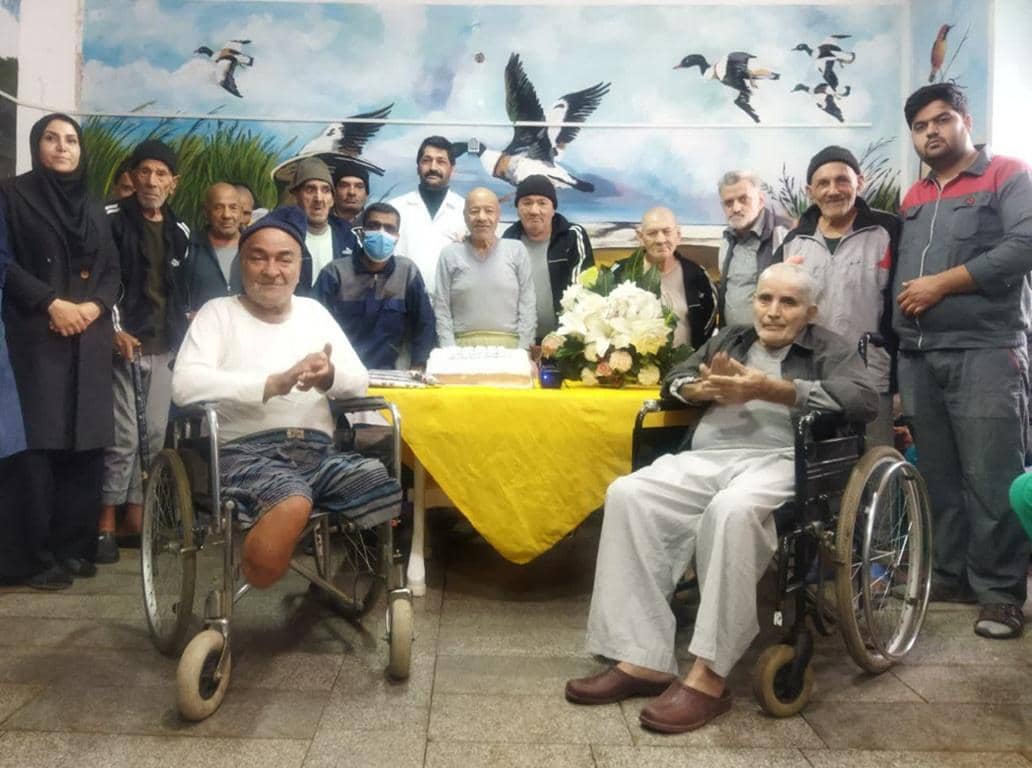 Elderly men in wheelchairs celebrating, with volunteers providing crypto for good healthcare aid in a community setting, supported by ETH.