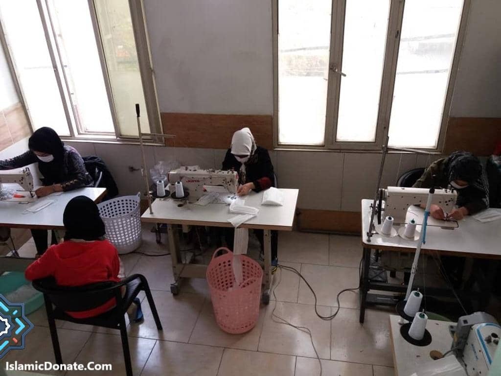 Women in a sewing workshop create items with sewing machines, showcasing skills and job training for income, supported by crypto donations like SOL.