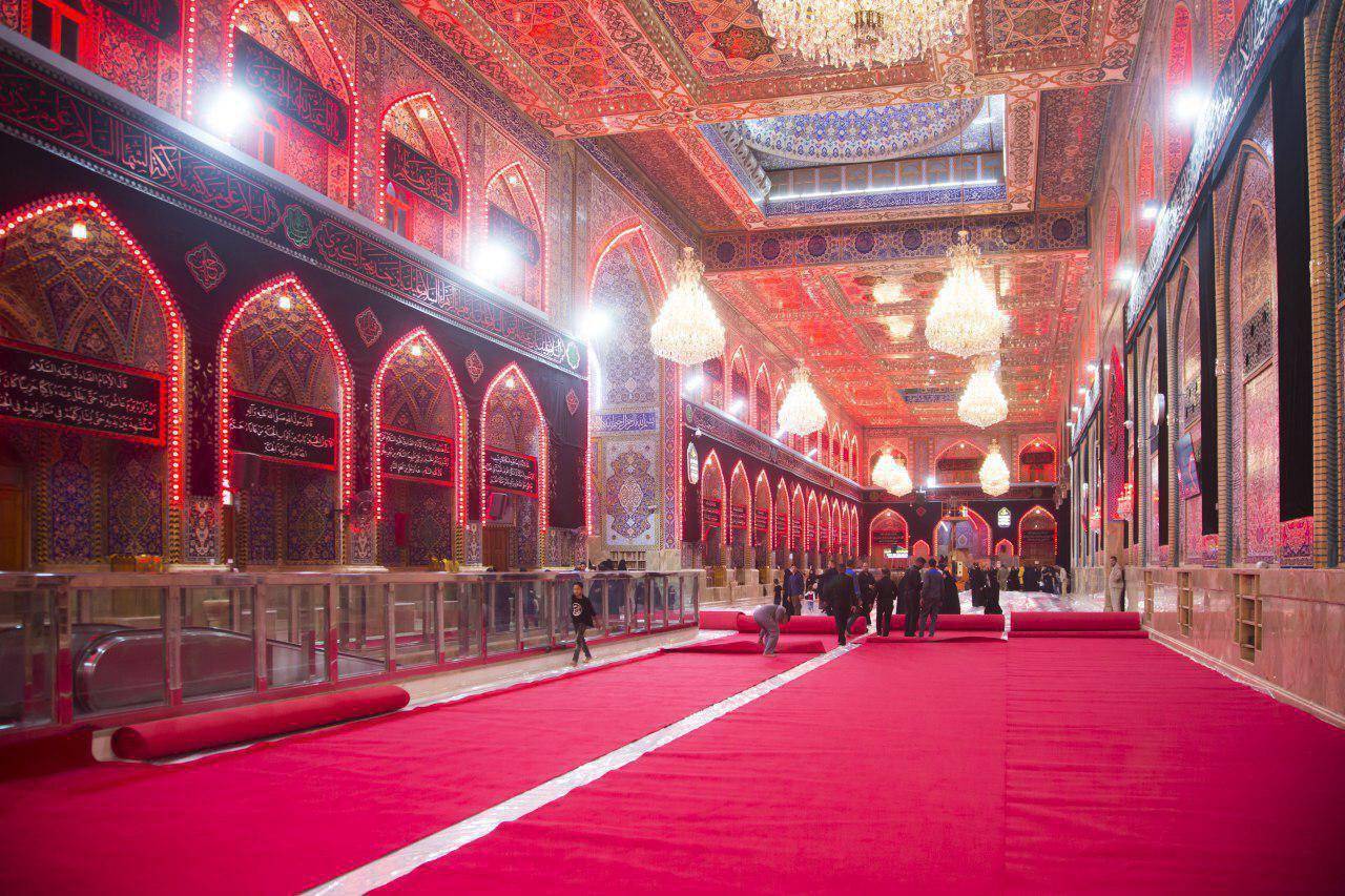 Interior of a grand hall with red carpets and ornate decorations, people walking on the carpet. Crypto donation for Nazr Mola and Kunde ki Niyaz via ETH.