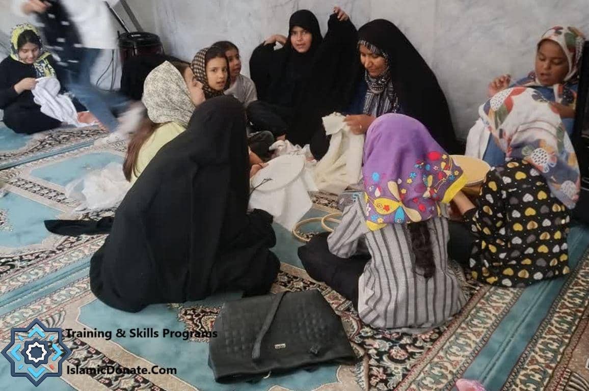 Group of Muslim women and girls learning sewing skills, receiving training for sustainable livelihoods through charitable donations. Cryptocurrency donations like BASE are accepted for these programs.
