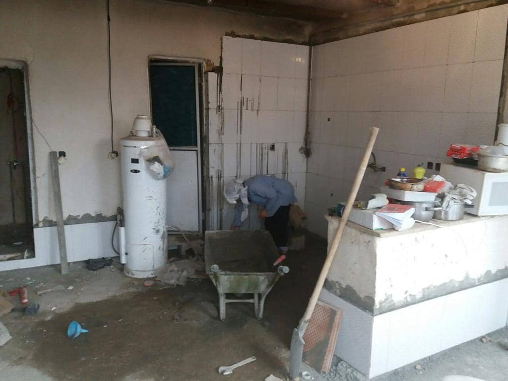 Construction or renovation in progress in a kitchen area with a person using a wheelbarrow and tools. Crypto zakat enables renovations like this, with donations via Stellar supporting essential projects.