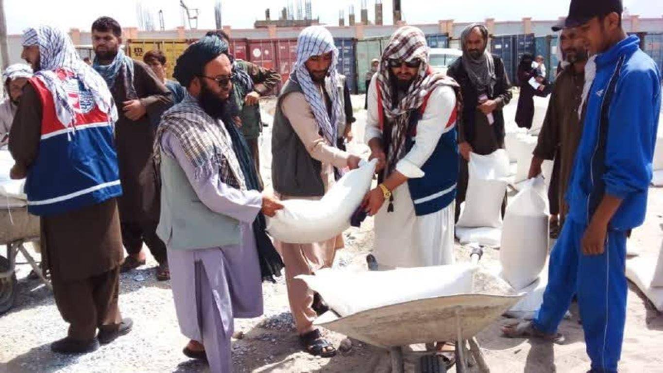 Afghan men distributing food and relief supplies being supported by crypto donations via RLUSD.