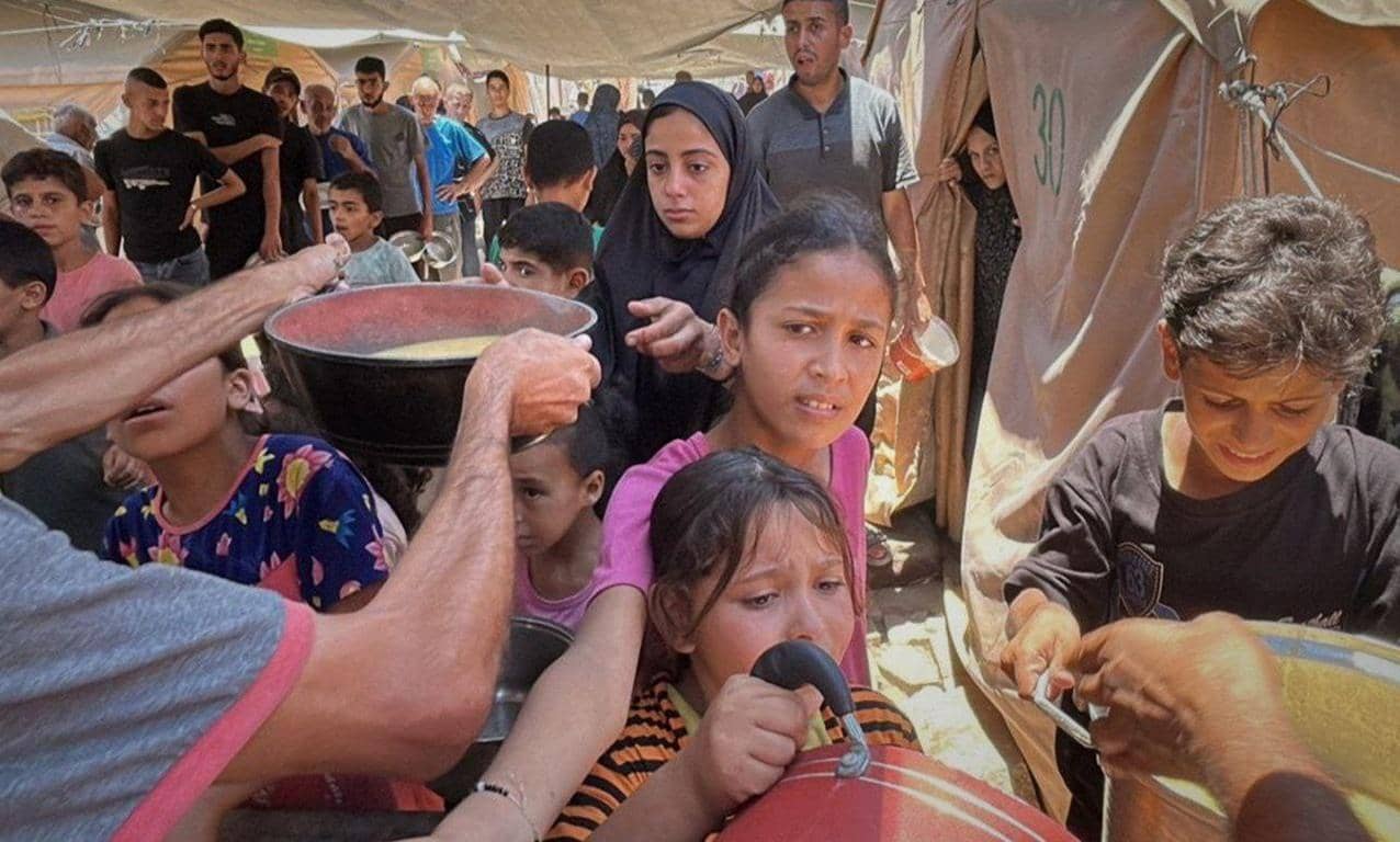 Children and adults in a humanitarian setting receiving food from large bowls. Digital crypto donations like Litecoin ensure help reaches those in need. Supports crypto donations for Laylatul Qadr.