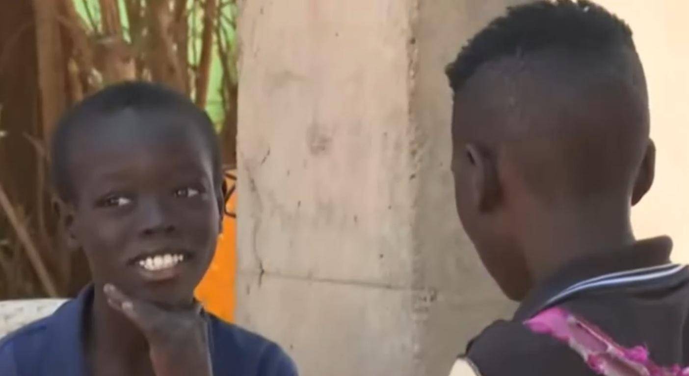 Two young boys interacting in Sudan, one with a hopeful expression. Crypto donations deliver essential aid, food, and medical care, including through BTC, to needy families.