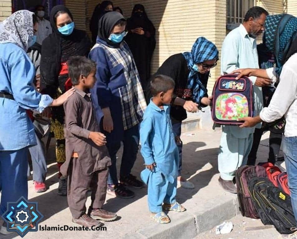 Children receiving backpacks for school, supported by crypto donations. A woman hands a colorful unicorn backpack to a young boy. This act of kindness aids orphans, providing education and shelter through crypto giving, possibly utilizing XRP for its global reach.