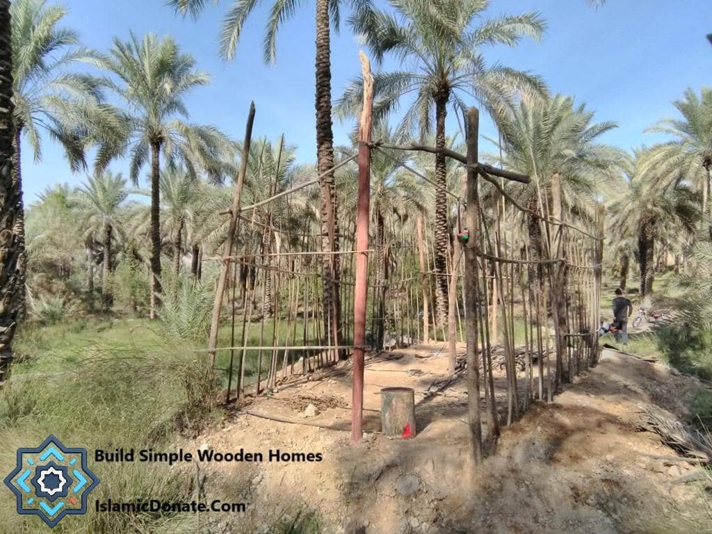 Date trees in arid land, with a fence under construction, symbolizing Sadaqah Jariyah and sustainable livelihoods, supported by generous crypto donations like ETH.