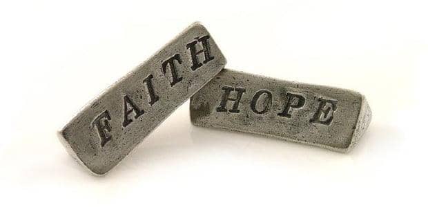 Two metal bars inscribed with FAITH and HOPE, representing the HODL Hope charity's mission of enduring commitment supported by crypto.