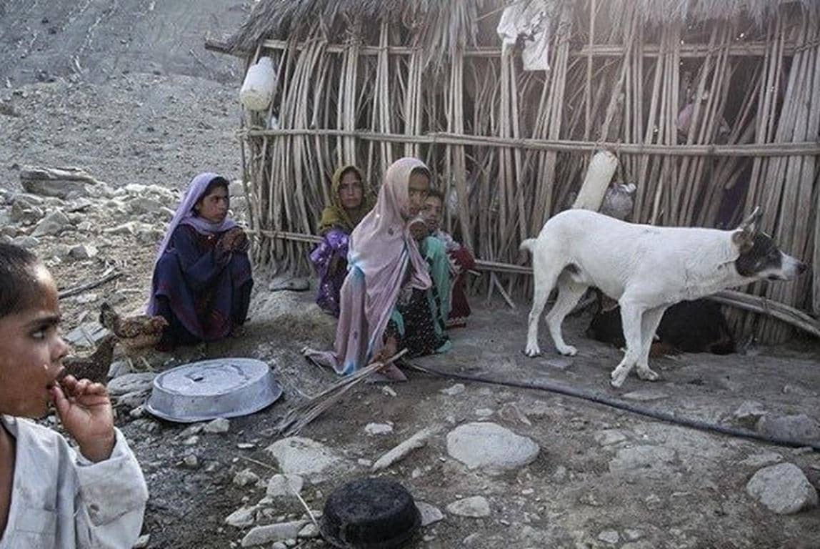 Children and a dog near a makeshift shelter, depicting hardship and the need for aid, exemplifying the direct impact of crypto Zakat donations.
