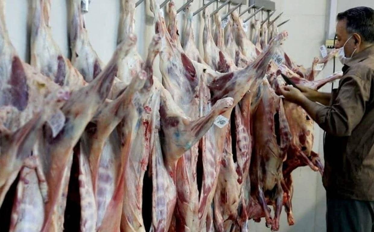 Qurbani meat hanging and a person inspecting it, symbolizing crypto donations for Eid al-Adha feeding the needy in Palestine with Dogecoin.