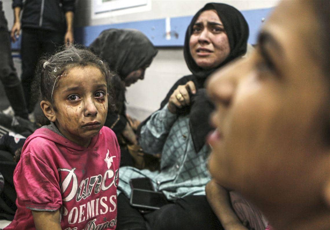 A young Palestinian child with tear-streaked, smudged face looks somberly ahead, while a woman cries in the background. Donations of crypto and aid help these displaced families in Palestine, with AVAX supporting critical needs like water and shelter.