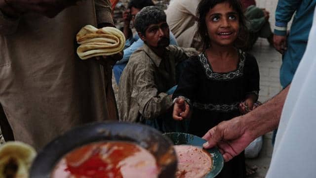 A young girl eagerly receives food distributed to needy individuals, with crypto donations enabling this relief effort.