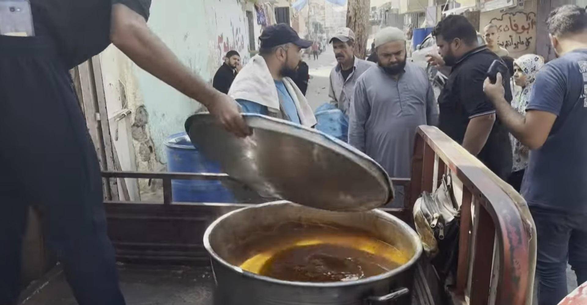 Aid in Palestine efforts serving food from a large pot, with volunteers preparing distribution supported by crypto via XRP.