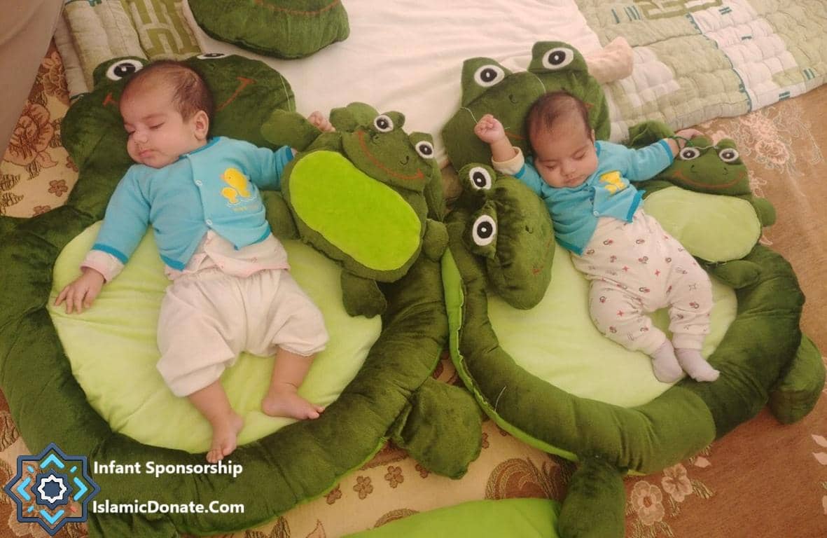 Two sleeping infants on plush frog toys, symbolizing sponsored orphans receiving care and support through cryptocurrency donations like ETH. Sponsor an orphan and help vulnerable children.