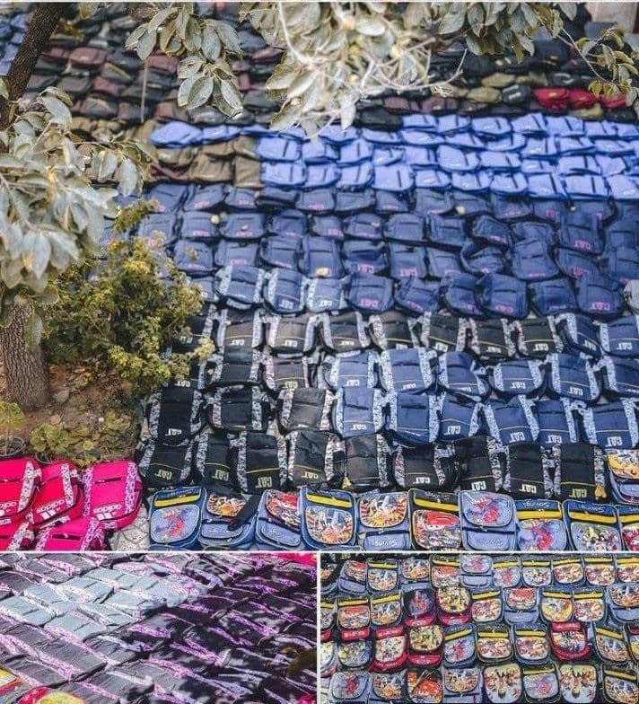 Rows of donated backpacks and school bags in various colors and designs, organized for distribution to children in need. This humanitarian effort for the Back to School report is supported by crypto donations, including ETH, empowering disadvantaged communities with educational resources. Sponsoring 200 orphans fosters a brighter future.
