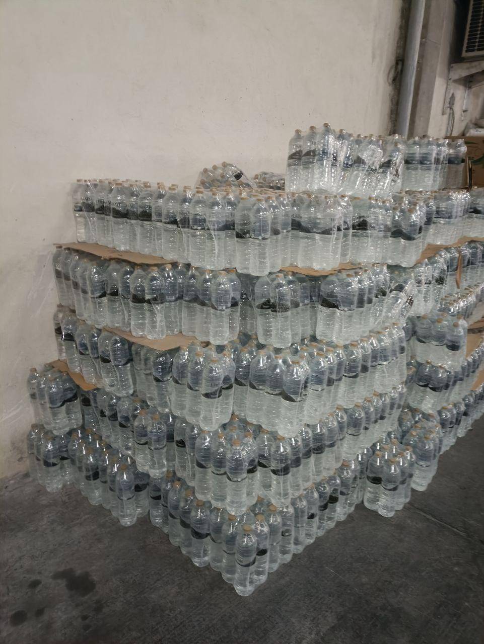 Large stacks of bottled water packaged in plastic wrap, ready for humanitarian aid distribution in Gaza. Donations via crypto like LTC provide essential water.