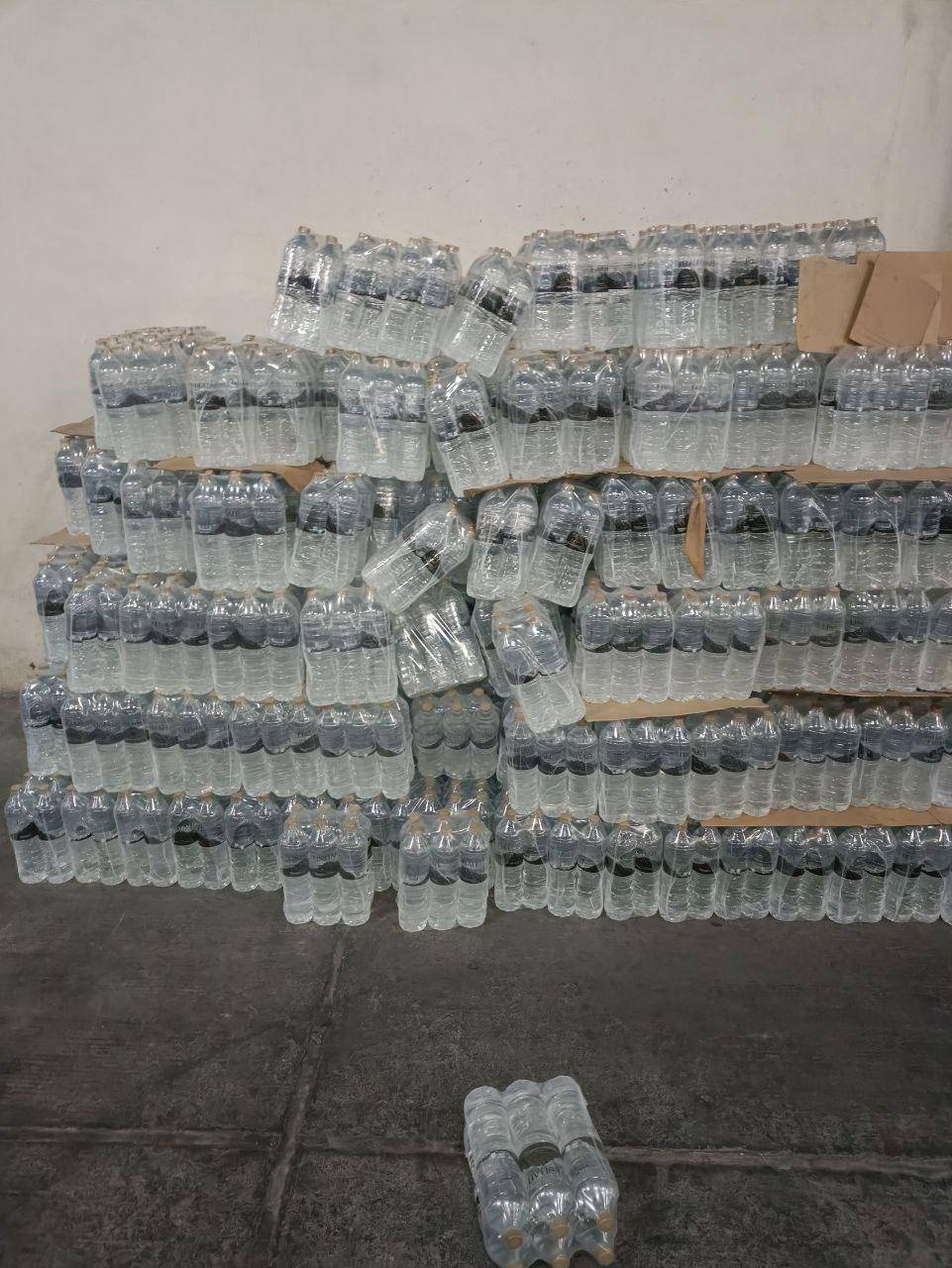 Stacks of bottled water aid for Gaza, a vital resource made possible through crypto donations like BTC.