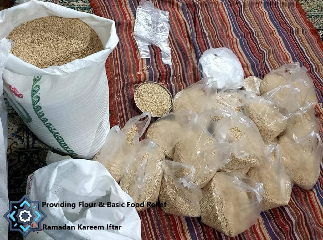 Providing flour and basic food relief for Ramadan Kareem iftar, a large sack of grain and multiple bags of flour are shown, implying crypto-funded aid.