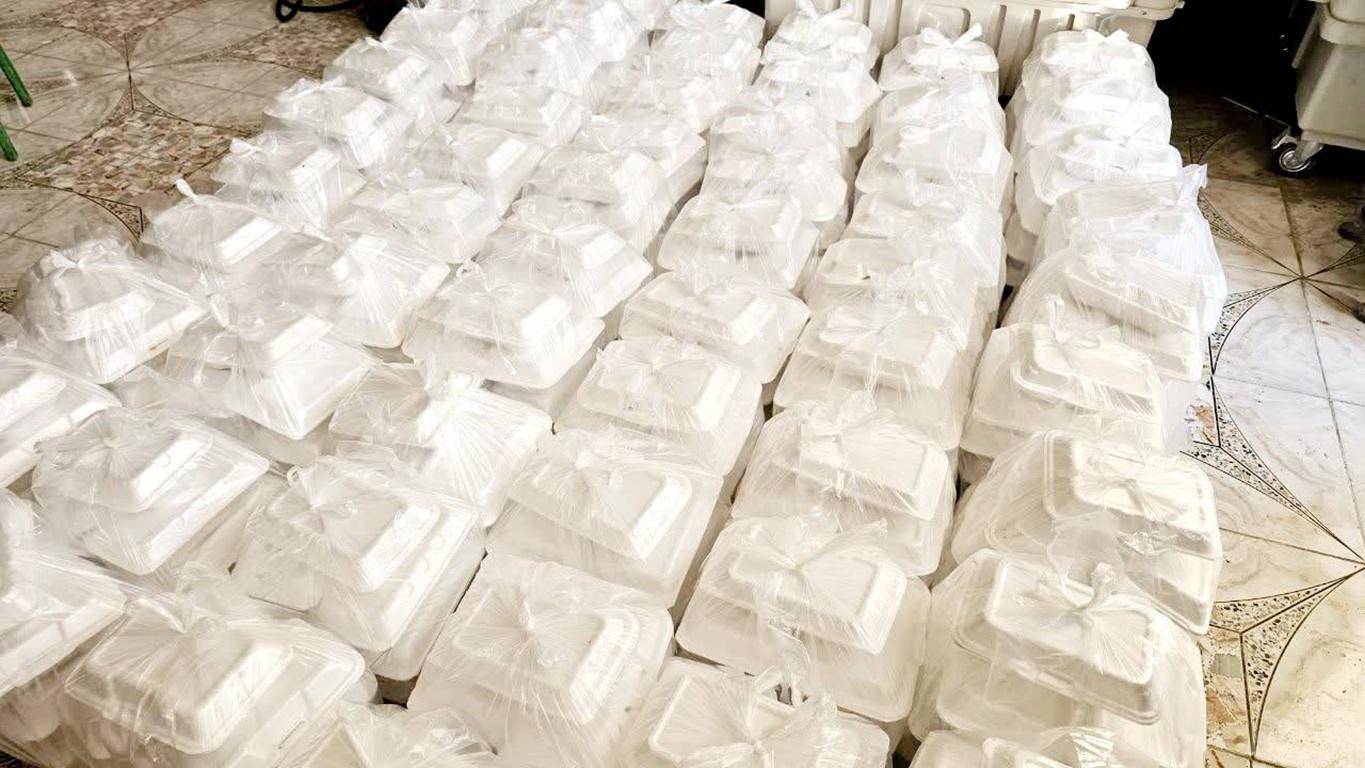 Stacks of white food containers, many bagged, ready for distribution. These reflect crypto zakat donations in action, providing meals to those in need through donations of BTC.