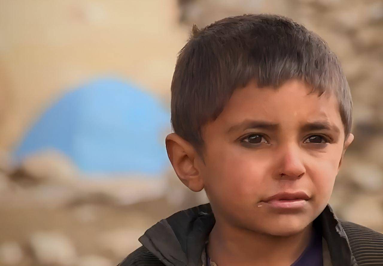Headshot of a young Palestinian boy with a direct gaze, symbolizing need. Your crypto Zakat, like SOL, can provide essential aid like food, water, and medical supplies for children and families in Palestine, supporting reconstruction efforts.