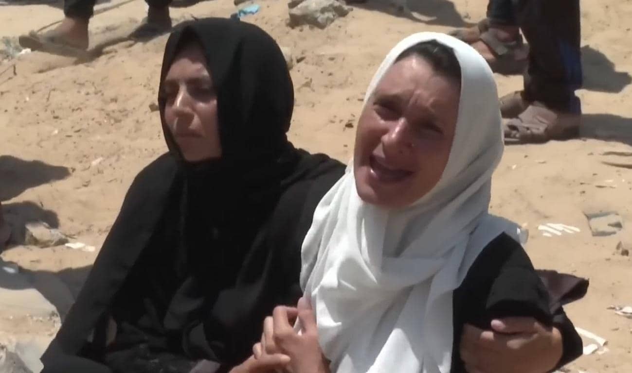Two women in distress, one crying, in a war-torn environment, reflecting the dire humanitarian crisis in Yemen and the need for aid, possibly supported by ETH donations.