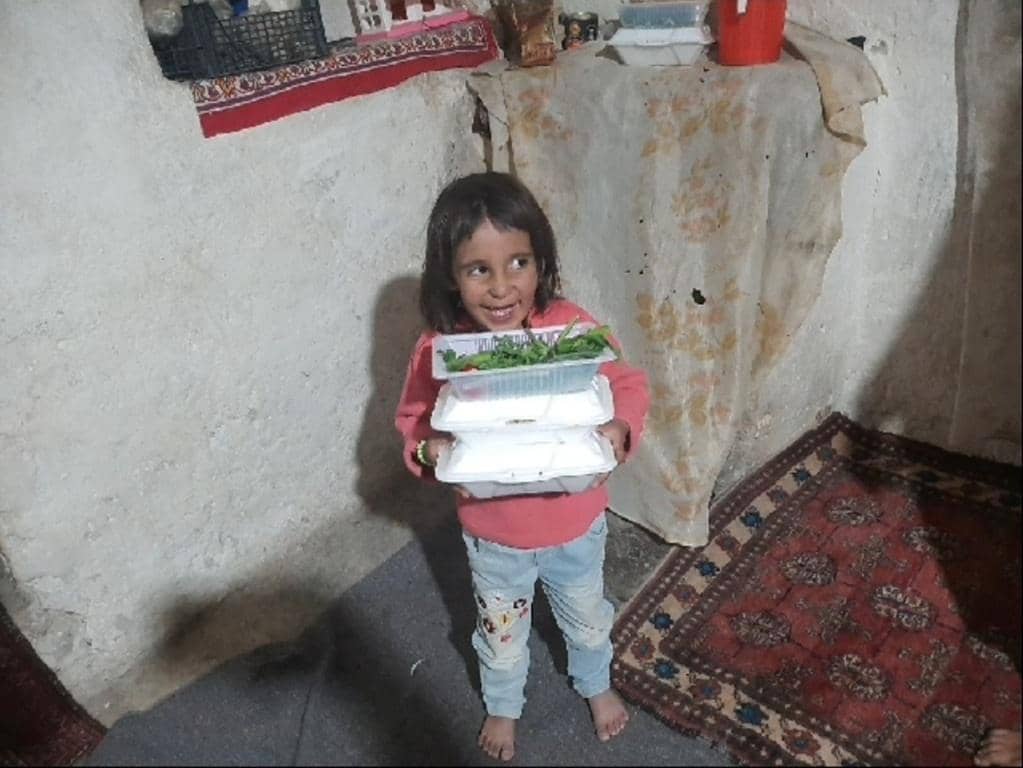Child holding stack of food containers, anonymous crypto donations providing meals to hungry families via XRP.