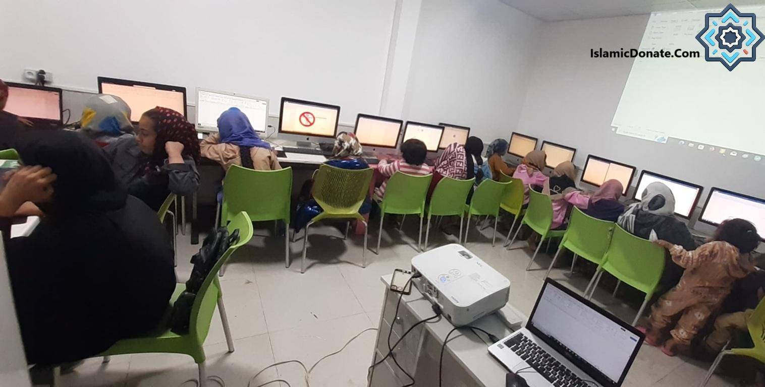 Children learning computer skills in a classroom, using computers and a projector. Donation made via crypto like USDT for digital privacy and security.