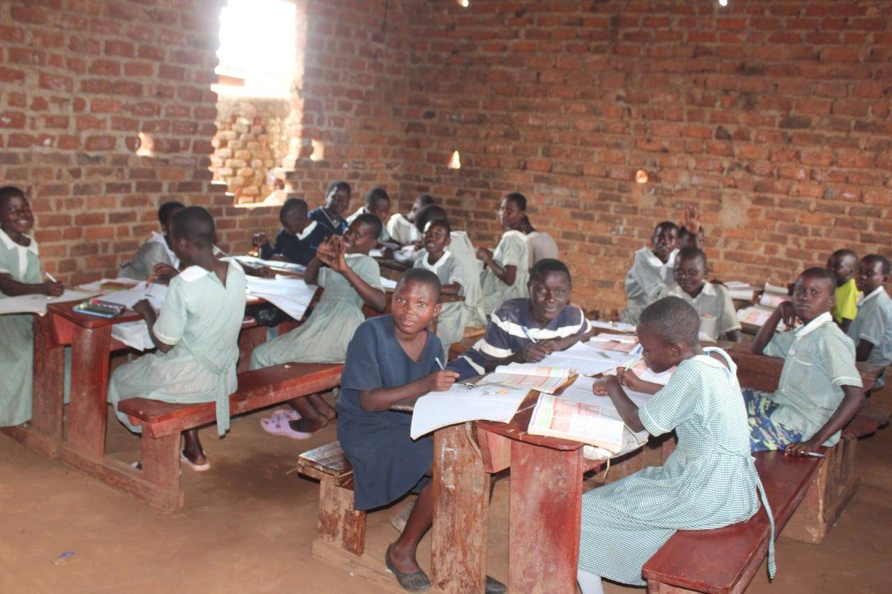 Children in a classroom, engaged in learning, benefit from educational support and crypto donations, fostering literacy and digital skills with USDT.