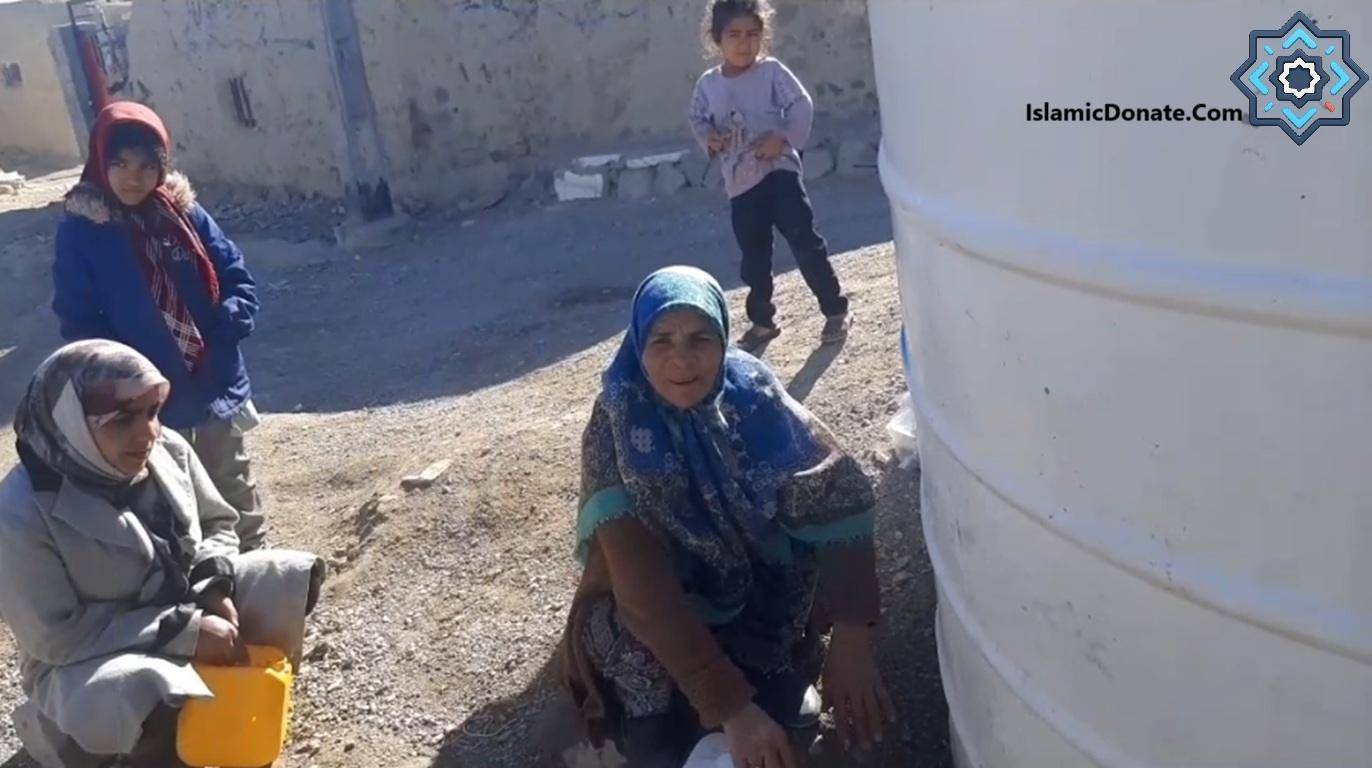 Children and women collecting water from a large tank, illustrating the impact of crypto donations for clean water initiatives.