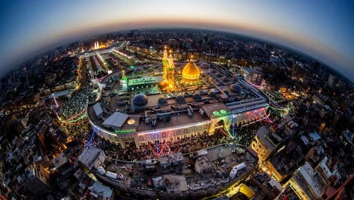Crowds gather at a shrine illuminated with lights, commemorating Imam Hussain's martyrdom. The image highlights sacrifice, integrity, and resistance against injustice, with donations supported by ETH to aid the vulnerable in Islamic relief efforts.